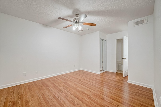 spare room with ceiling fan, a textured ceiling, and light hardwood / wood-style flooring