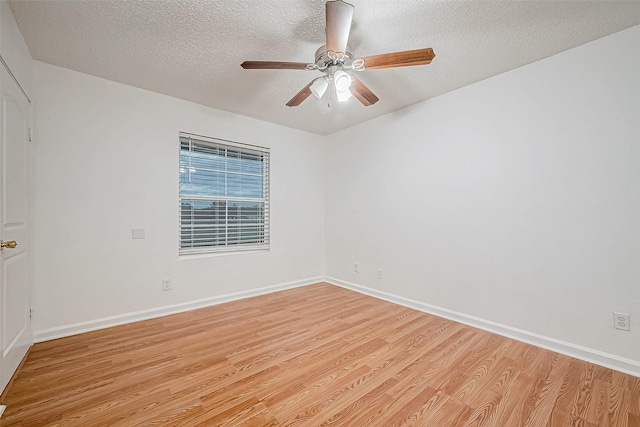 empty room featuring ceiling fan, light wood-type flooring, and a textured ceiling