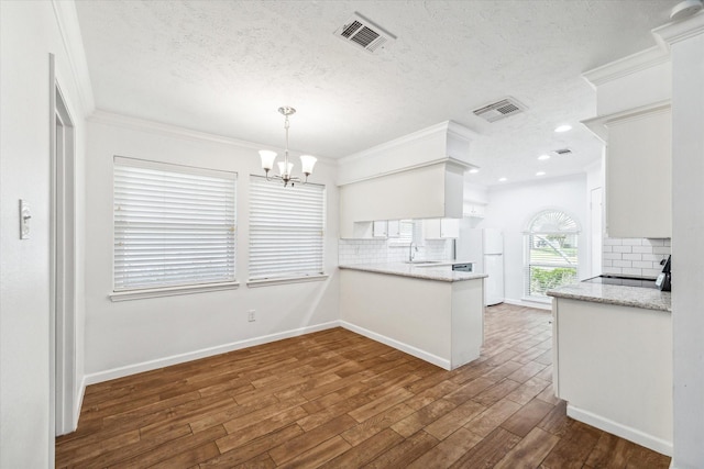 kitchen with white refrigerator, sink, white cabinetry, and dark wood-type flooring