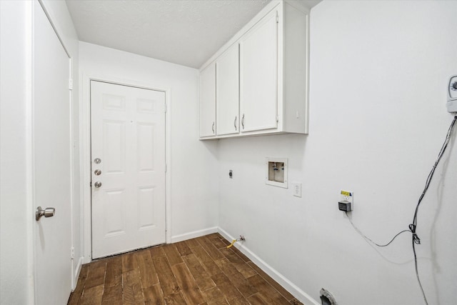 clothes washing area featuring cabinets, washer hookup, dark hardwood / wood-style flooring, a textured ceiling, and hookup for a gas dryer