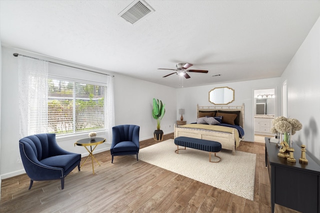 bedroom featuring hardwood / wood-style flooring, ceiling fan, and connected bathroom