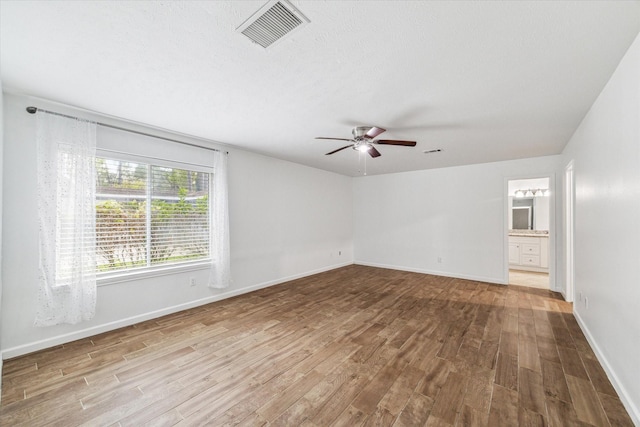 spare room with ceiling fan, wood-type flooring, and a textured ceiling