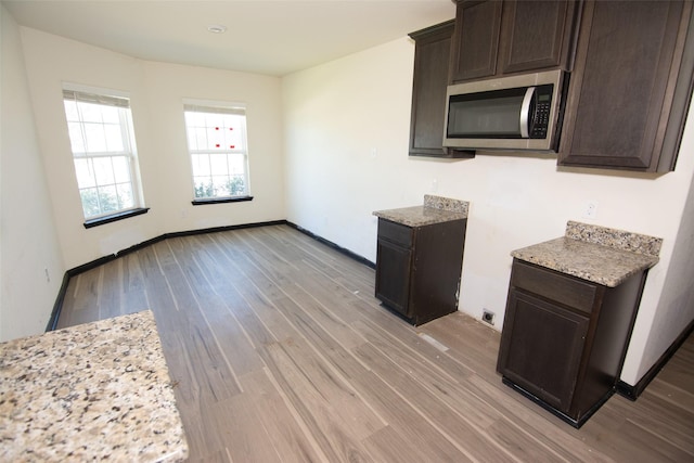 kitchen featuring dark brown cabinets and light hardwood / wood-style floors