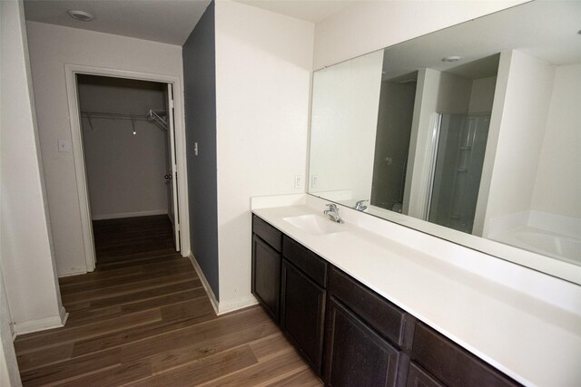 bathroom featuring vanity, wood-type flooring, and walk in shower