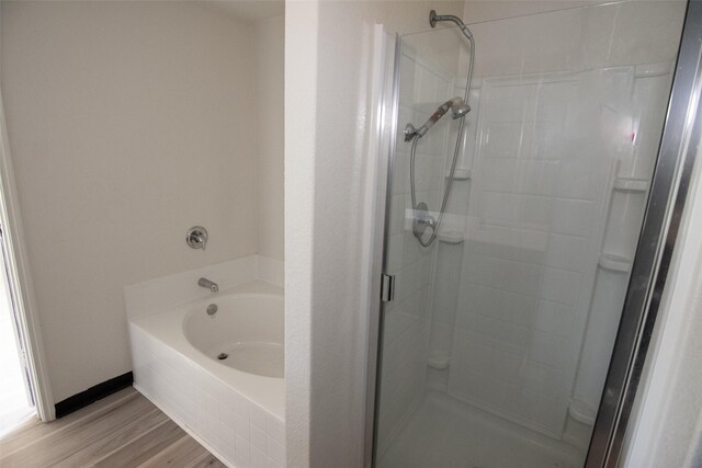 bathroom featuring hardwood / wood-style flooring and separate shower and tub