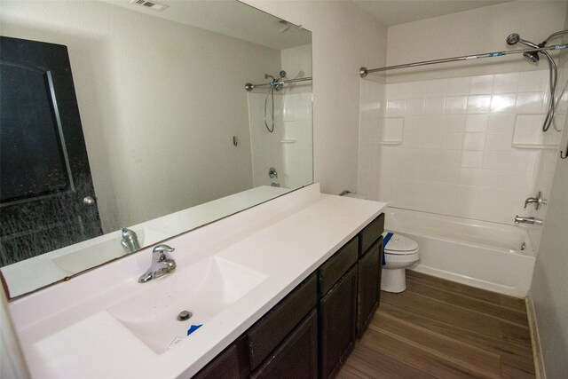 full bathroom featuring hardwood / wood-style flooring, vanity, toilet, and bathing tub / shower combination