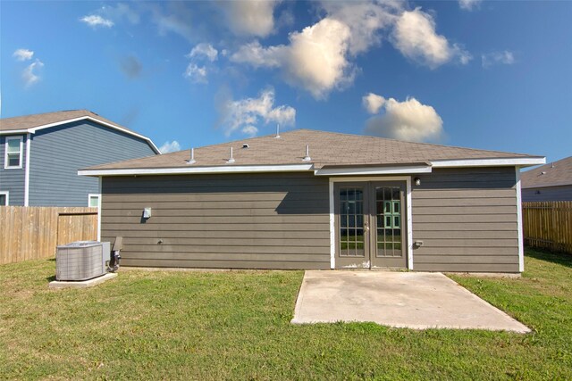 back of property with central AC unit, a patio area, a yard, and french doors