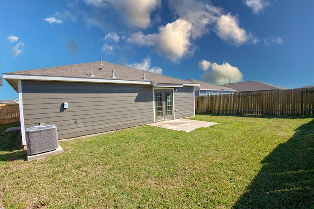 rear view of house featuring central air condition unit, a yard, and a patio