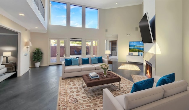 living room with wood-type flooring, a high ceiling, and french doors