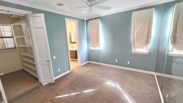 unfurnished bedroom with carpet flooring, ensuite bathroom, ceiling fan, and crown molding