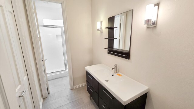 bathroom with vanity and a shower with door