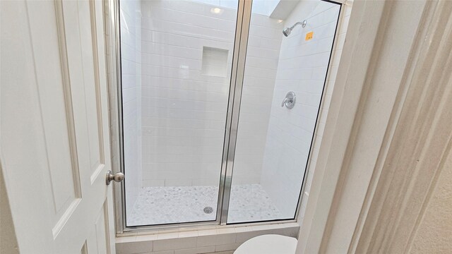 bathroom featuring an enclosed shower and toilet