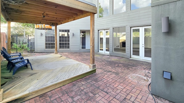 wooden terrace with a patio and french doors