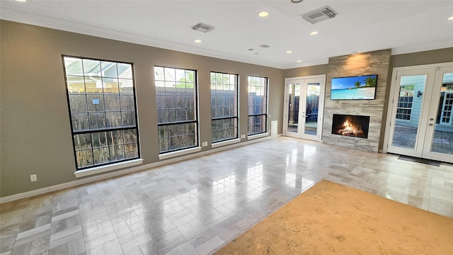 unfurnished living room with a fireplace, french doors, and ornamental molding