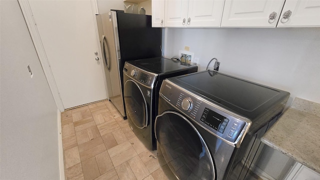 washroom with cabinets and washing machine and dryer