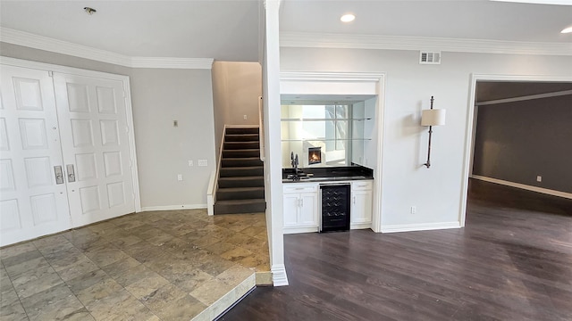 kitchen featuring white cabinets, sink, ornamental molding, dark hardwood / wood-style flooring, and beverage cooler