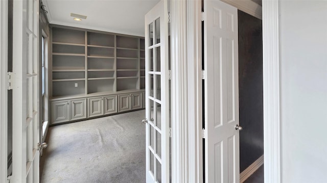 hallway with carpet flooring, crown molding, and french doors