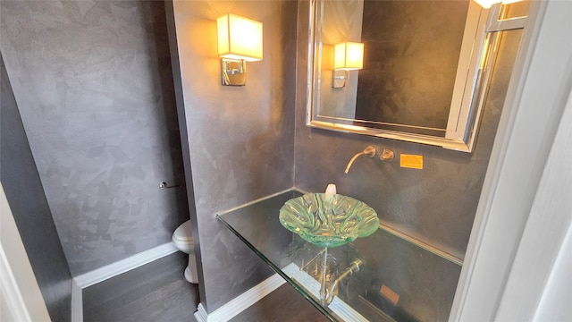 bathroom featuring hardwood / wood-style flooring and toilet