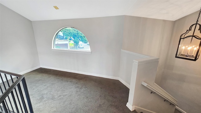 interior space with carpet floors and vaulted ceiling