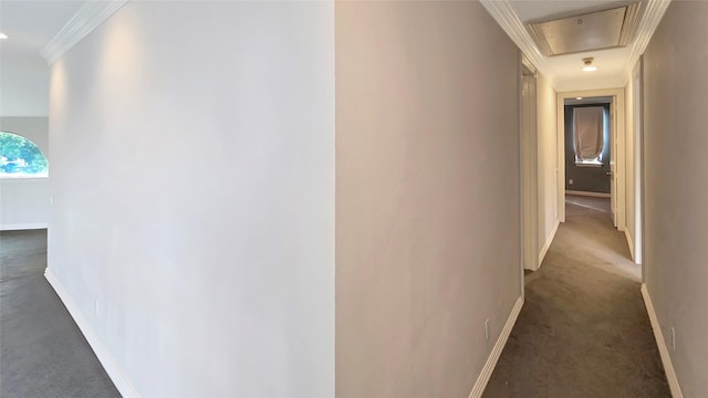 hall with dark colored carpet and ornamental molding