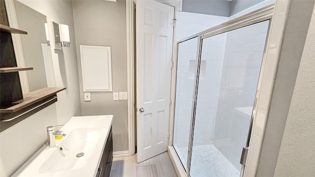 bathroom with wood-type flooring, vanity, and an enclosed shower