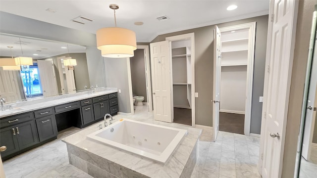 bathroom with vanity, tiled bath, toilet, and crown molding