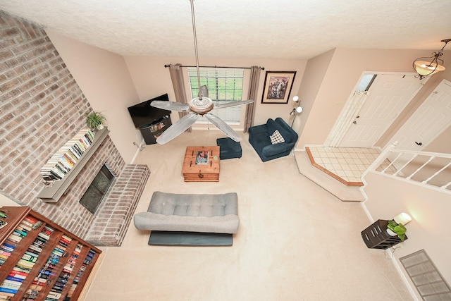 living room with a textured ceiling, carpet floors, and a fireplace