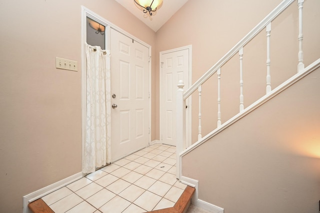 foyer featuring lofted ceiling and light tile patterned flooring