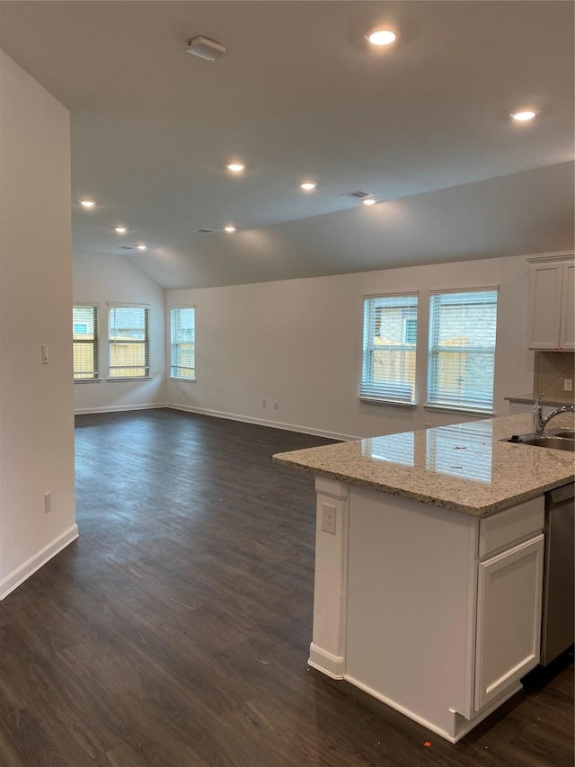 kitchen featuring stainless steel dishwasher, white cabinets, lofted ceiling, and a wealth of natural light