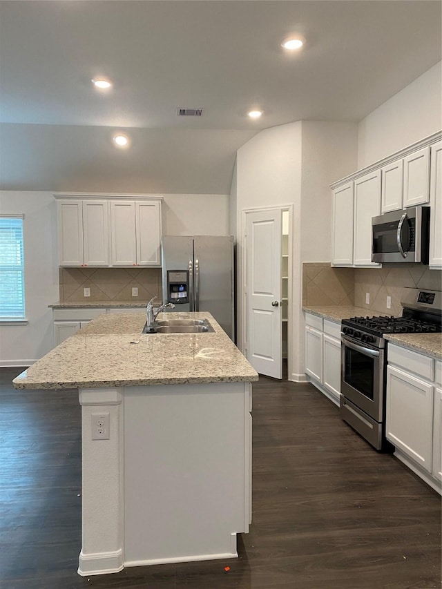 kitchen with appliances with stainless steel finishes, dark hardwood / wood-style flooring, a center island with sink, and sink