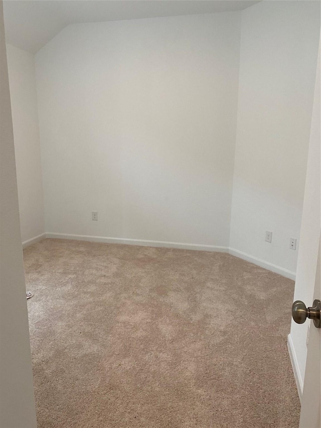 carpeted spare room featuring lofted ceiling