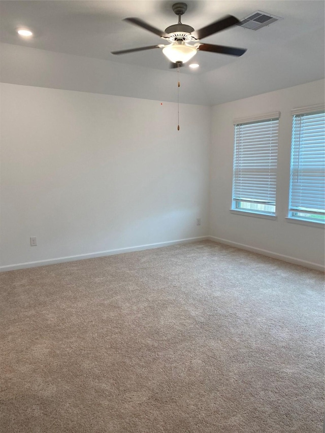 spare room with ceiling fan and light carpet