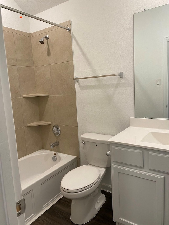 full bathroom featuring toilet, vanity, wood-type flooring, and tiled shower / bath