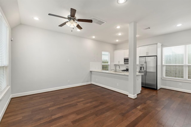 unfurnished living room featuring ceiling fan, sink, lofted ceiling, and dark wood-type flooring