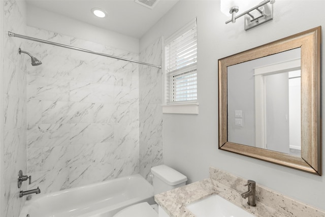 full bathroom featuring tiled shower / bath combo, toilet, and vanity