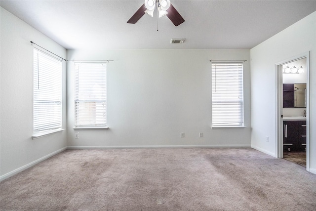 empty room with light carpet, plenty of natural light, and ceiling fan