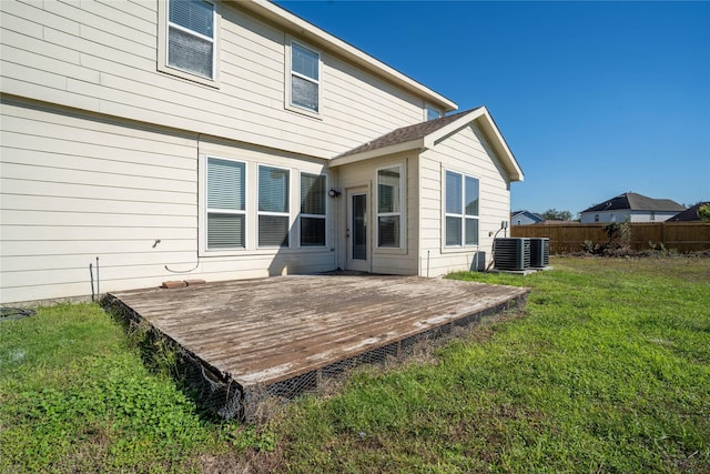 back of house with a lawn, cooling unit, and a wooden deck