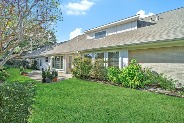 rear view of property featuring a lawn