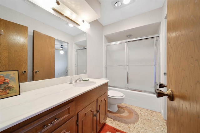 full bathroom with combined bath / shower with glass door, vanity, and toilet