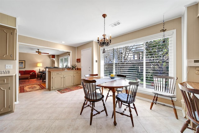 tiled dining area with plenty of natural light and ceiling fan with notable chandelier