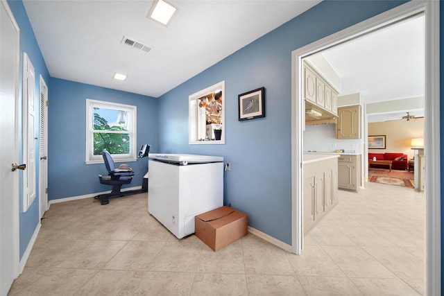 clothes washing area with ceiling fan and light tile patterned floors