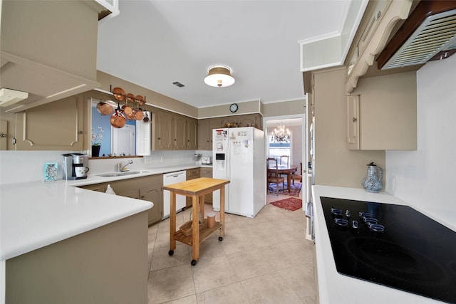 kitchen with kitchen peninsula, white appliances, sink, a chandelier, and light tile patterned flooring