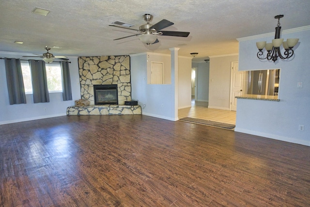 unfurnished living room featuring a textured ceiling, ceiling fan with notable chandelier, crown molding, hardwood / wood-style flooring, and a fireplace