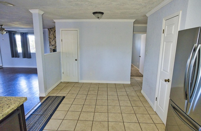 interior space with ornamental molding, a textured ceiling, stainless steel refrigerator, and light hardwood / wood-style flooring