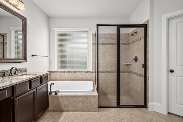 bathroom featuring plus walk in shower, vanity, and tile patterned floors