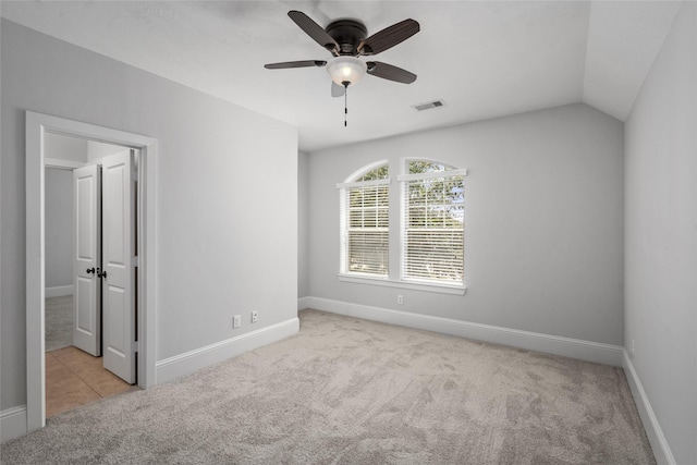 unfurnished bedroom with ceiling fan, light carpet, and vaulted ceiling