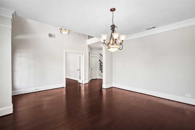 interior space featuring a notable chandelier, ornamental molding, and dark wood-type flooring