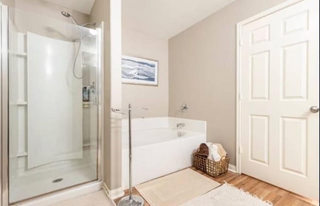 bathroom featuring shower with separate bathtub and hardwood / wood-style flooring