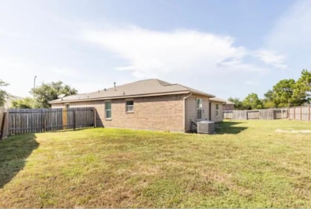 exterior space with central air condition unit and a lawn