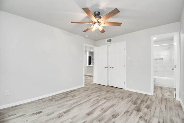 unfurnished bedroom with connected bathroom, a closet, light hardwood / wood-style flooring, and ceiling fan